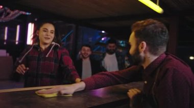Müşteri gelmeden önce modern bir barmenin bar masasını temizlerken müşterilerine içki hazırlarken çok heyecanlı bir şekilde içmeye başlarlar.