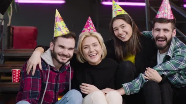 Framför kameran med ett stort vitt leende multietniska vänner firar en födelsedagsfest njuter av ögonblicket tittar rakt in i kameran — Stockvideo