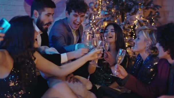 Boa atmosfera de festa no grupo de ano novo de jovens muito belos que celebram em conjunto aplaudem com copos de champanhe e apreciando a noite. 4k — Vídeo de Stock