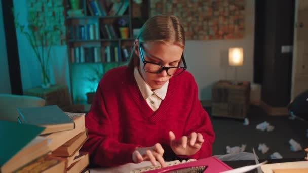 Estudiante inteligente dama en casa haciendo su tipo de proyecto algunos documentos en la máquina de escribir que ella hace muy cara de pensamiento — Vídeos de Stock
