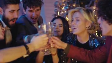 Büyük gülüşlü güzel bayanlar ve partide eğlenen çekici erkekler şampanya kadehleriyle tezahürat yapıp rahatlıyorlar. ARRI Alexa Mini 'de çekilen