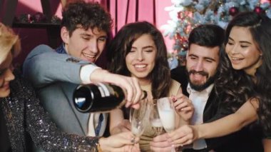 Noel partisinde birlikte kutlama yapan bir grup işçi ellerinde şampanya bardakları ve atmosferin tadını çıkarıyorlar.