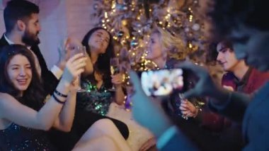 Noel partisinde güzel bir grup arkadaş akıllı bir telefonla dans ederken biraz kokteyl içip atmosferin tadını çıkarıyorlar. 4k