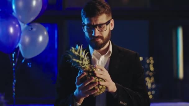 Le jeune homme devant la caméra passe un drôle de moment à la fête il joue avec un ananas puis il jette l'ananas — Video