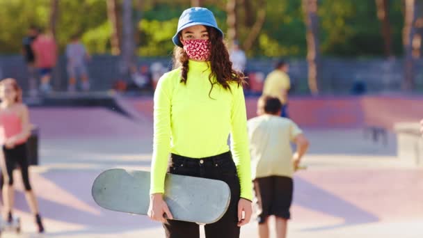 在一场大流行中，2019年亚洲女子在一个滑板公园里，在一个阳光明媚的日子里，在摄像机前摘下她的保护膜 — 图库视频影像