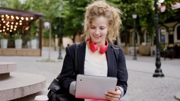 Sorrindo grande incrível olhando fêmea em uma roupa de negócios segurando tablet eletrônico ter um tempo de pausa ela passar o intervalo fora no meio da rua — Vídeo de Stock