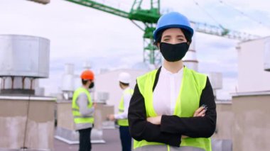 Kamera konsepti Covid-19 'un önünde duran koruyucu maskeli ve kasklı karizmatik bayan mühendise yakın çekim. ARRI Alexa 'da çekim