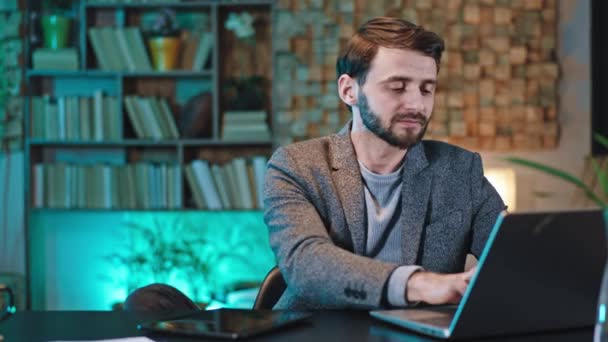 Bello uomo d'affari molto rilassato ed eccitato al suo posto di lavoro in ufficio fare una pausa guardando dritto alla fotocamera e sorridendo grande — Video Stock