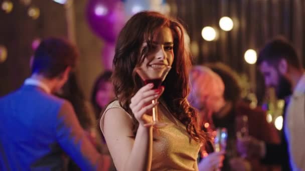 Geburtstagsparty junge Frau genießt die Party, trinkt einen Cocktail vor der Kamera und lächelt breit — Stockvideo
