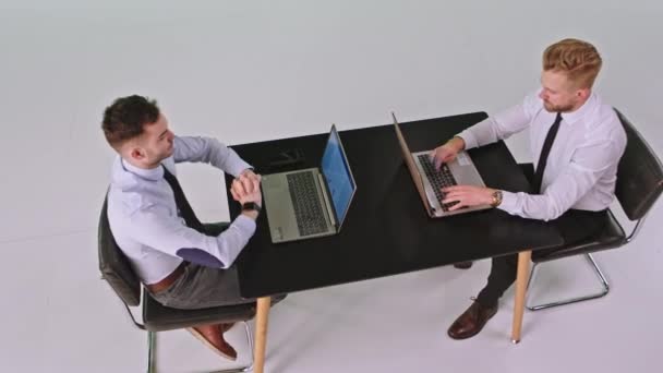 In de groene achtergrond studio kantoormedewerker mannen werken geconcentreerd op zijn laptops typen iets — Stockvideo