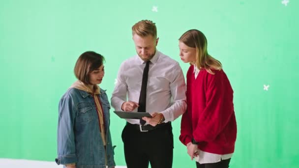 Студія зеленого фону красиві студентки мають інтерв'ю зі своїм потенційним менеджером офісу вони використовують цифровий планшет, щоб показати свою cv — стокове відео
