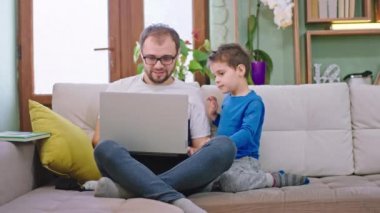 Çekici bir baba ve oğlu kanepede hız yapıyor. Dizüstü bilgisayarlarını film izlemek için kullanıyorlar. Evde otururken çok güzel vakit geçiriyorlar.