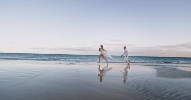 Deniz kenarında çok romantik bir çift. Suda koşuyorlar ve özgürlüklerini hissediyorlar. — Stok video