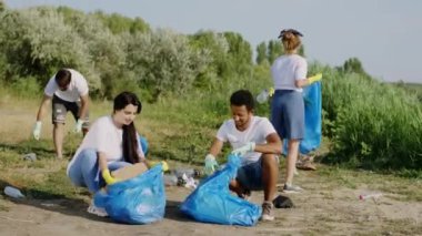Gezegeni kurtarma kavramı, koruyucu eldiven takan, mavi plastik torbalardaki çöpleri toplayan genç çok ırklı gönüllülerden oluşan plastik bir grup oluşturur.