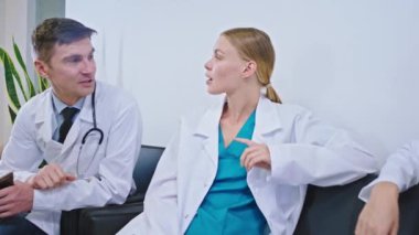 Çekici doktor ve hemşireler, dijital tablette oynadıkları malzeme odasında ara verdiler. Büyük gülümsemeler sergiliyorlar.
