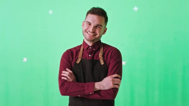 Posando frente a la cámara hombre barista con una gran sonrisa en un estudio de croma key que tiene cruzando las manos mirando directamente a la cámara — Vídeos de Stock