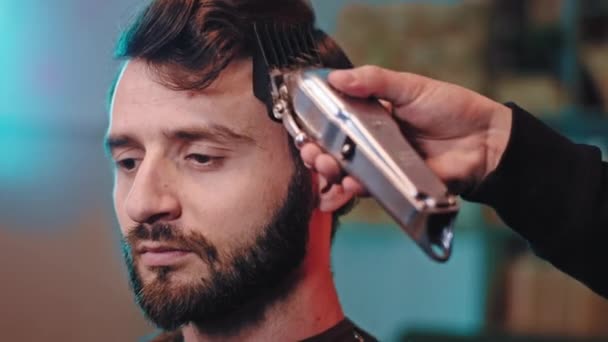 Ritratto di un uomo nel barbiere hanno un uomo barbiere taglio di capelli professionale con clipper professionale nero — Video Stock