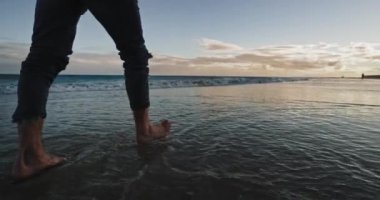 Sahilde yürüyen bir adamın videosunu çekiyorum. Tek başına eğleniyor, meditasyon yapıyor.