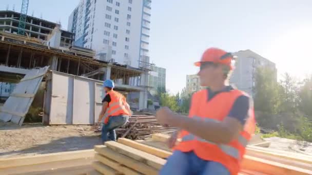 Diversos especialistas muito engraçados no canteiro de obras dançando e aproveitando o tempo no canteiro de obras Afro-americano começam a dançar na frente da câmera ele ouvindo música dos fones de ouvido. Tiros. — Vídeo de Stock