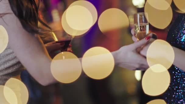 Detailní informace na party dvě dámy drží sklenice šumivého vína a třesoucí se ruce před fotoaparátem — Stock video