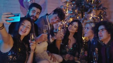 Noel partisinde Noel ağacının yanında kutlama yapan bir grup olgun güzel arkadaş hatıraları için selfie çekiyorlar. ARRI Alexa Mini 'de çekilen