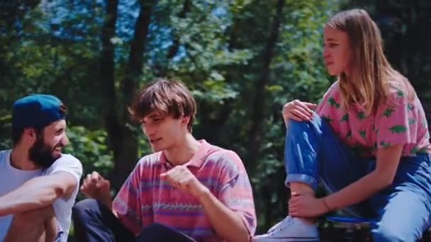 美丽的女士，带着完美的笑容和两个年轻男子在一个现代的溜冰场，他们在一起社交之前，开始滑板在一个完美的阳光灿烂的一天 — 图库视频影像