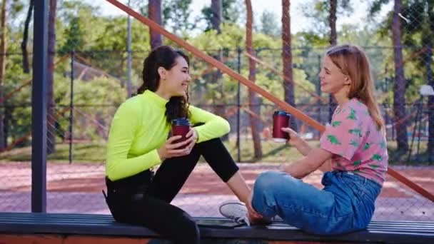 Donne multietniche amiche nel parco godendo il tempo al caffè discutendo insieme sentirsi felici e liberi prendere un po 'd'aria fresca — Video Stock