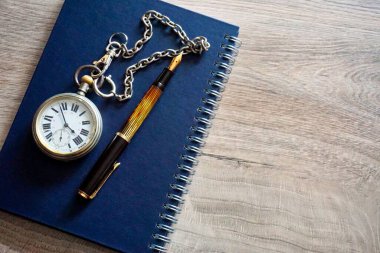 Masada zincir ve dolma kalemle çok eski bir cep saati.