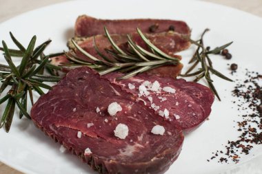 Sığır eti basturma baharat ve biberiye ile bir plaka üzerinde.