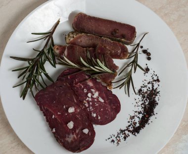 Sığır eti basturma baharat ve biberiye ile bir plaka üzerinde.