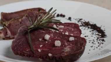 Sığır eti basturma baharat ve biberiye ile bir plaka üzerinde.