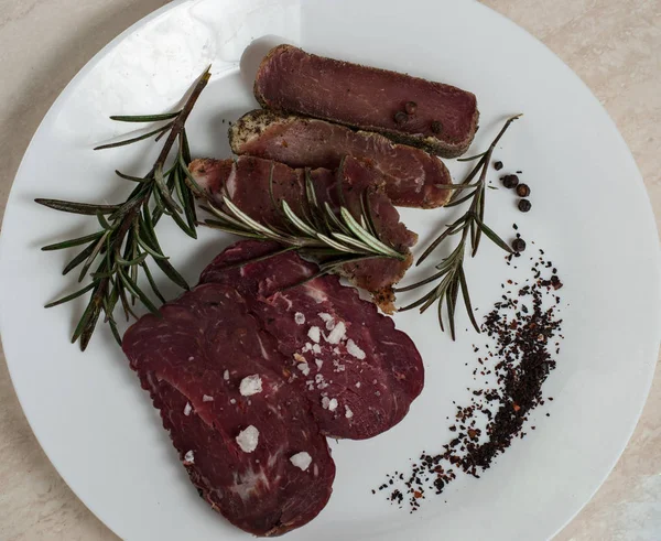 Sığır eti basturma baharat ve biberiye ile bir plaka üzerinde.