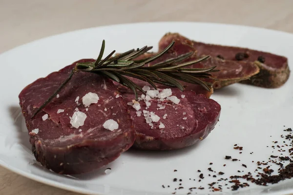 Sığır eti basturma baharat ve biberiye ile bir plaka üzerinde.