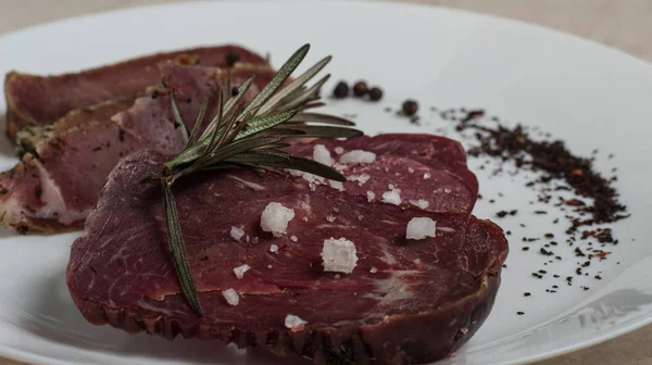 Sığır eti basturma baharat ve biberiye ile bir plaka üzerinde.