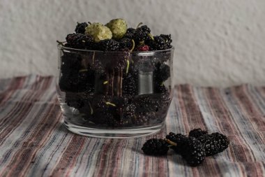 mulberry in a glass bowl on the table clipart