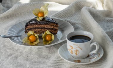 Avusturya milli pastası ile masada Zaher kek. Physalis ile dekore edilmiştir. Ve bir fincan kahve.