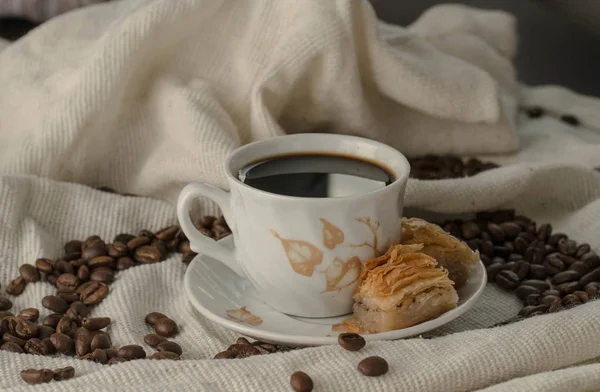 Kahve ve baklava masada, tahıllı bir masa örtüsünün üzerinde.