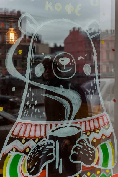 drawing of a bear with a cup of coffee on the glass window