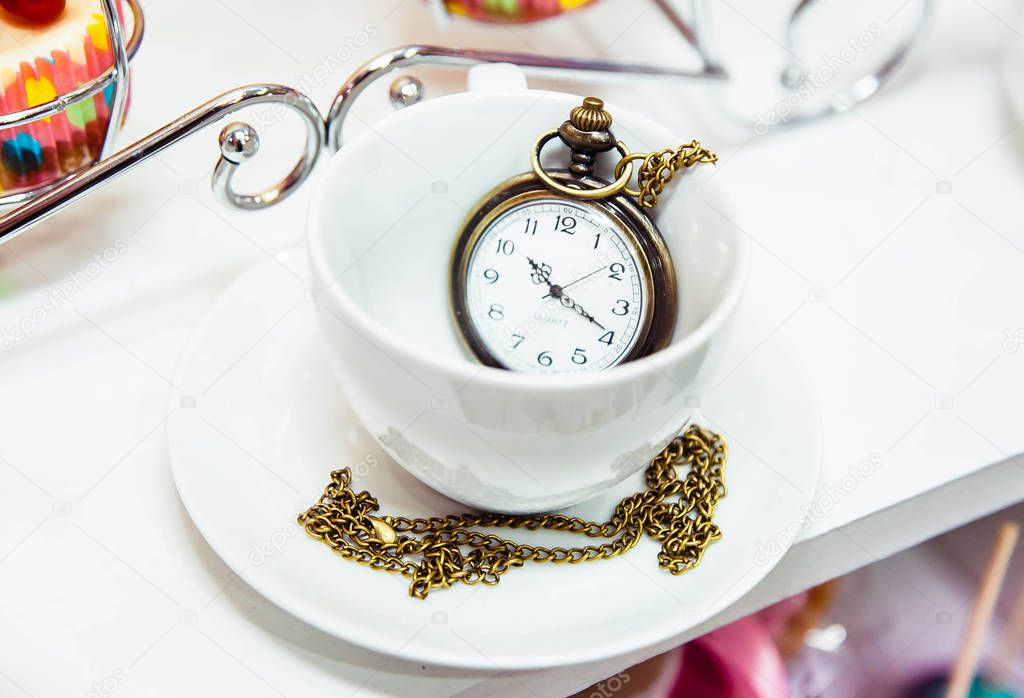 vintage clock in a tea cup decoration in Alice in Wonderland style