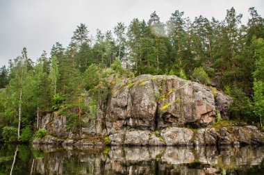 Sakin bir gölün kıyısındaki ilkel kayalar