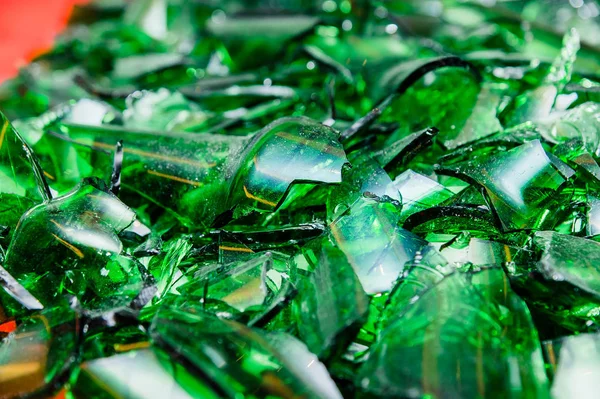 pile of pieces of broken green bottle glass