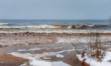 Kış denizinin önündeki ince buzun altında sel.