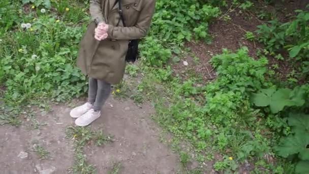 一个女孩站在那里揉搓着双手 而不是走在田野里的小路上 — 图库视频影像