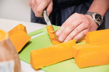 Eller balkabağını parçalara ayırdı. Aşçı sebze çorbası hazırlar.