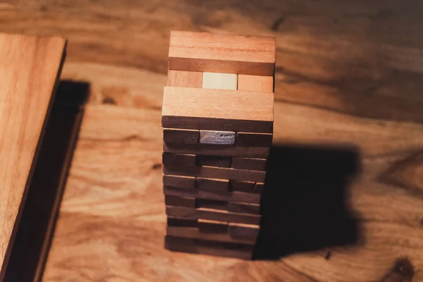 The game Jenga is on the table in the bar. The view from the top. Interactive wooden toy for a fun company.