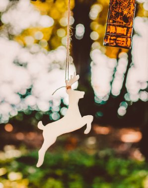 Ağaçtan bir geyik ve bir cam parçası sarkıyor. Aksesuarlar, oyuncaklar ve kırsal tarzda el yapımı dekorlar.