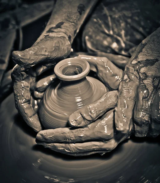 The hands of a master Potter help the girl to sculpt a jug. Master class in the production of ceramic tableware