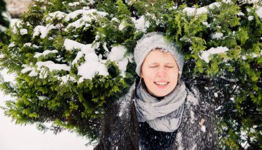 Kar altında gülen bir kız Kürk ağacından düşüyor