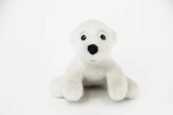 白い背景に座ってフェルトウールで作られたおもちゃのホッキョクグマ — ストック写真