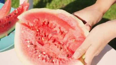 Sıcak bir yaz gününde piknikte karpuz dilimleri kesmek.